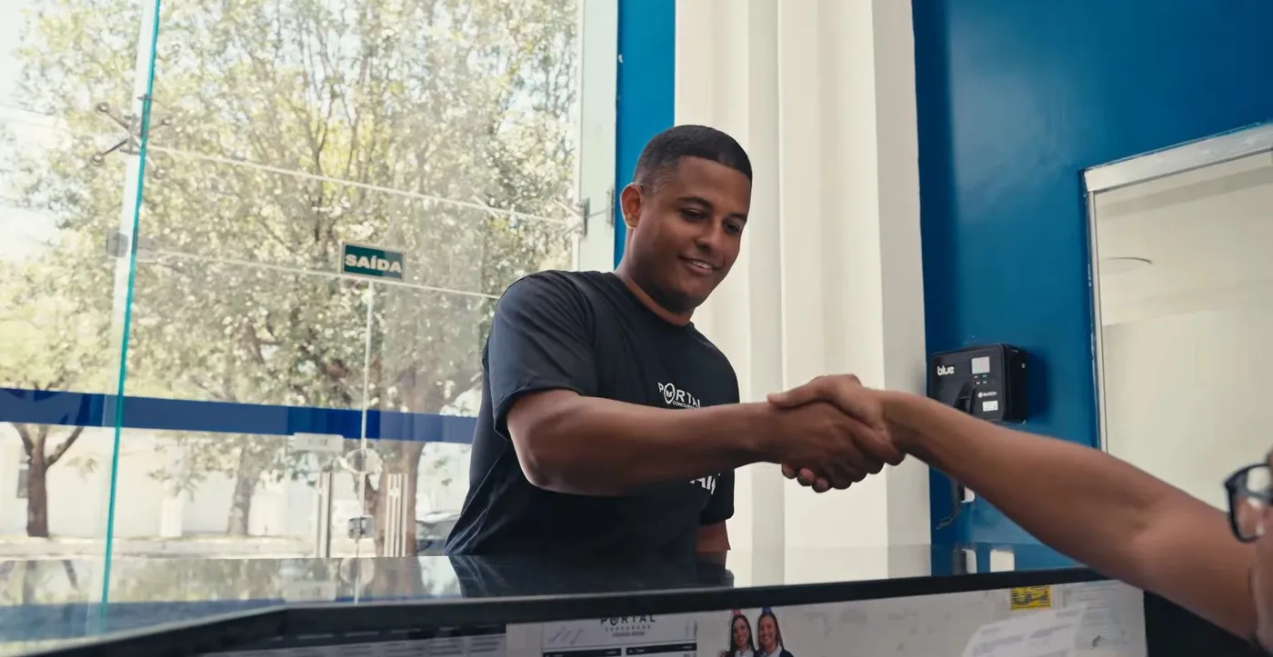 Raphael Martins cumprimentando uma pessoa na recepção do Portal Concursos