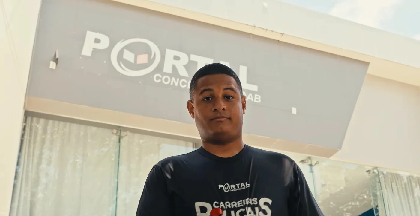 Raphael Martins diante da fachada do Portal Concursos